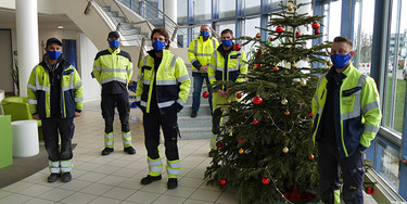 Die Mitglieder der Weihnachtsbereitschaft der Stadtwerke Unna stehen um einen Weihnachtsbaum
